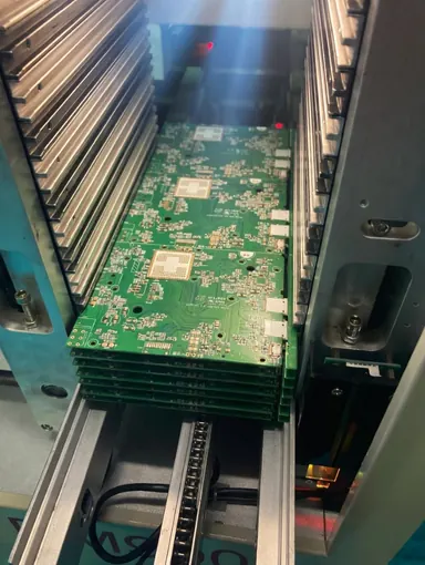 PCB assemblies moving through production equipment at the PCBA PARTNER facility