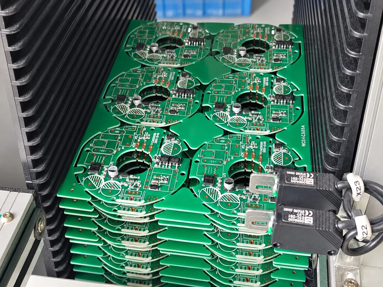 Assembled PCB panels held in a slotted magazine.