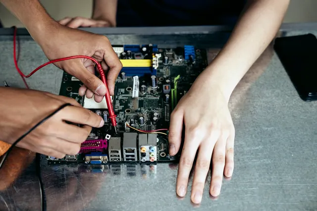 Technicians probing test points on a populated motherboard
