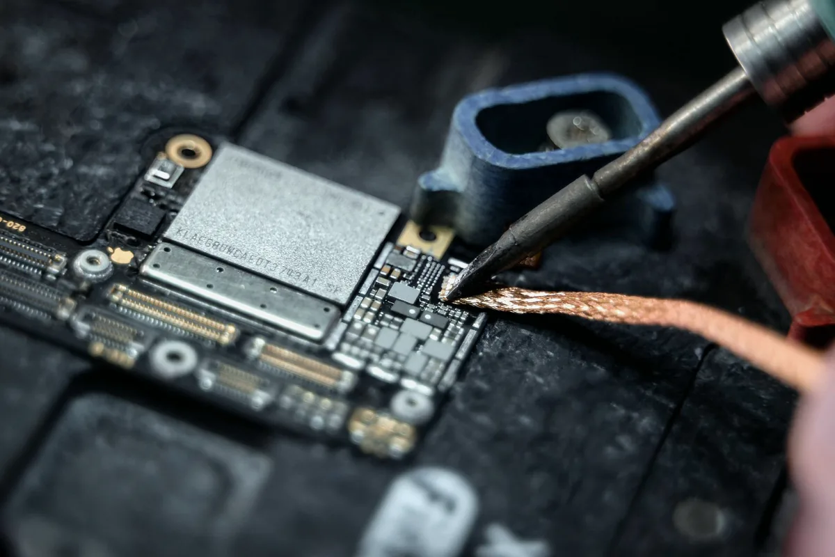 Close-up of a soldering process on a printed circuit board assembly