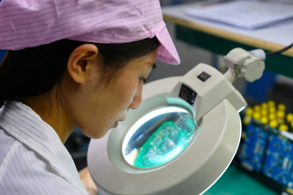 Prototype PCBA inspection under magnifier